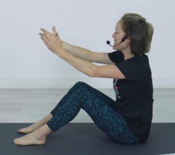 Woman preparing for Pilates seated exercise