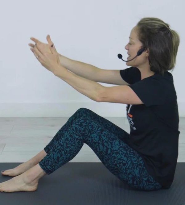 Woman preparing for Pilates seated exercise